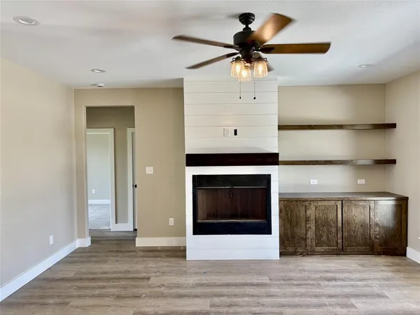 a view of a livingroom with a ceiling fan and hardwood floor