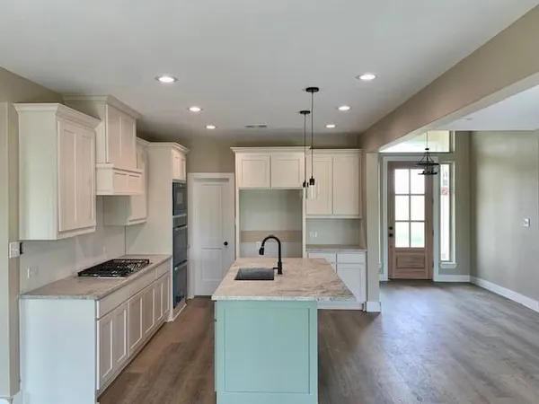 a kitchen with a sink cabinets and wooden floor