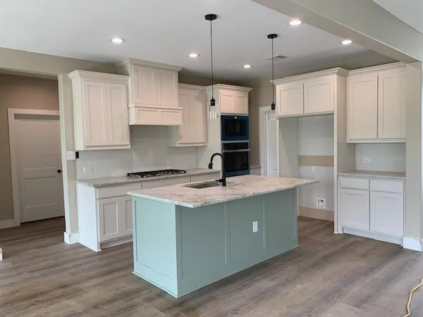 a kitchen with kitchen island a sink stainless steel appliances and cabinets