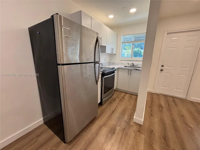 a view of a refrigerator in kitchen and wooden floor