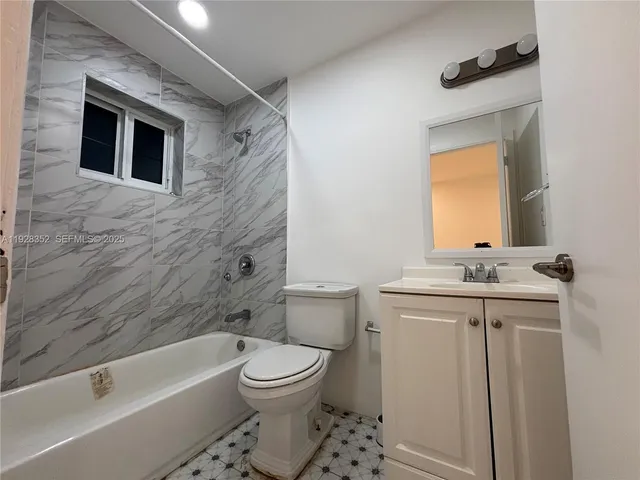 a bathroom with a granite countertop toilet a sink and a bathtub