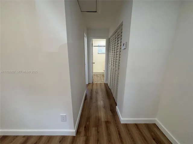 a view of a hallway with wooden floor