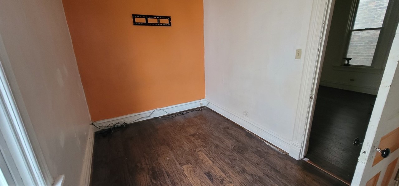 5604 South May Street Chicago, IL 60621 - Photo 7 of 9 an empty room with wooden floor