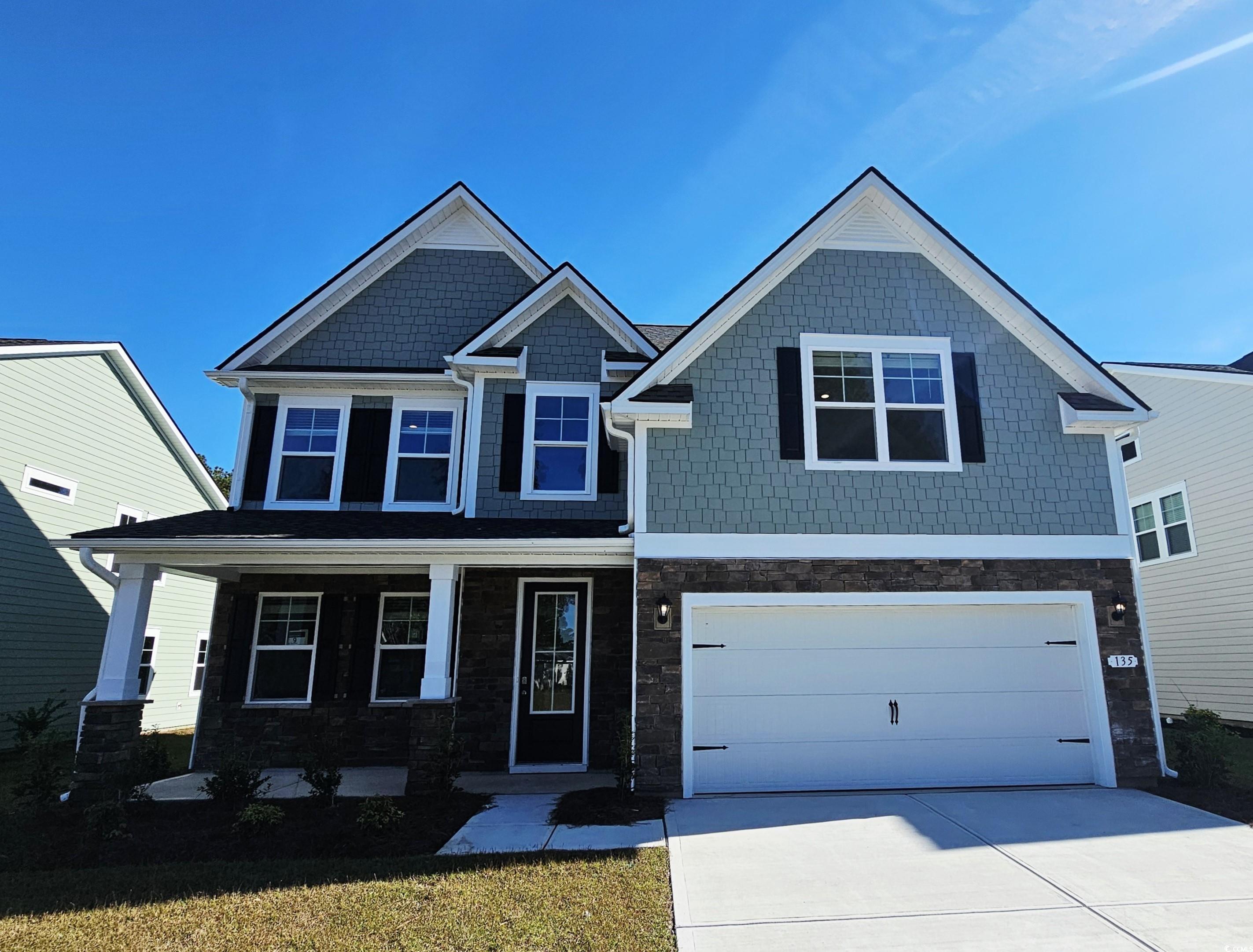 Craftsman house featuring a porch, stone siding, and driveway