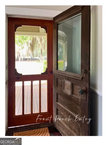 a view of an empty room with wooden floor fireplace and a window