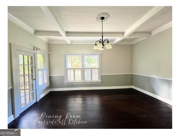 a view of a big room with wooden floor and windows