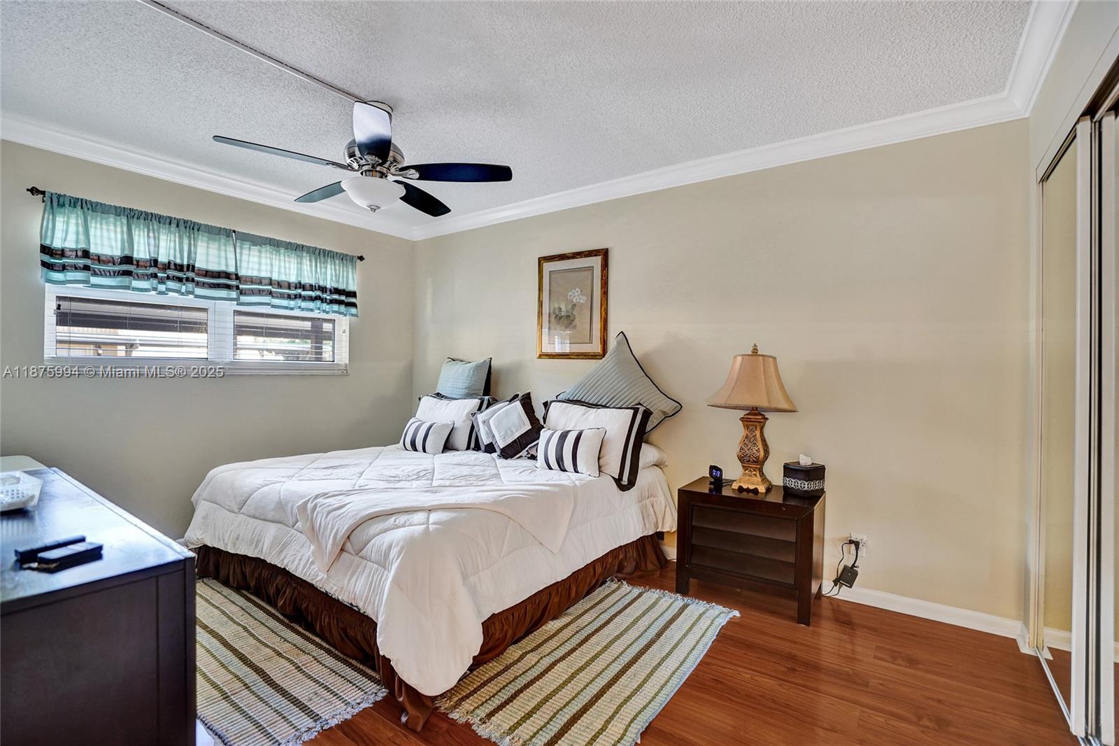 2975 Southwest 22nd Avenue, Unit 102 Delray Beach, FL 33445 - Photo 31 of 73 a bedroom with bed and wooden floor