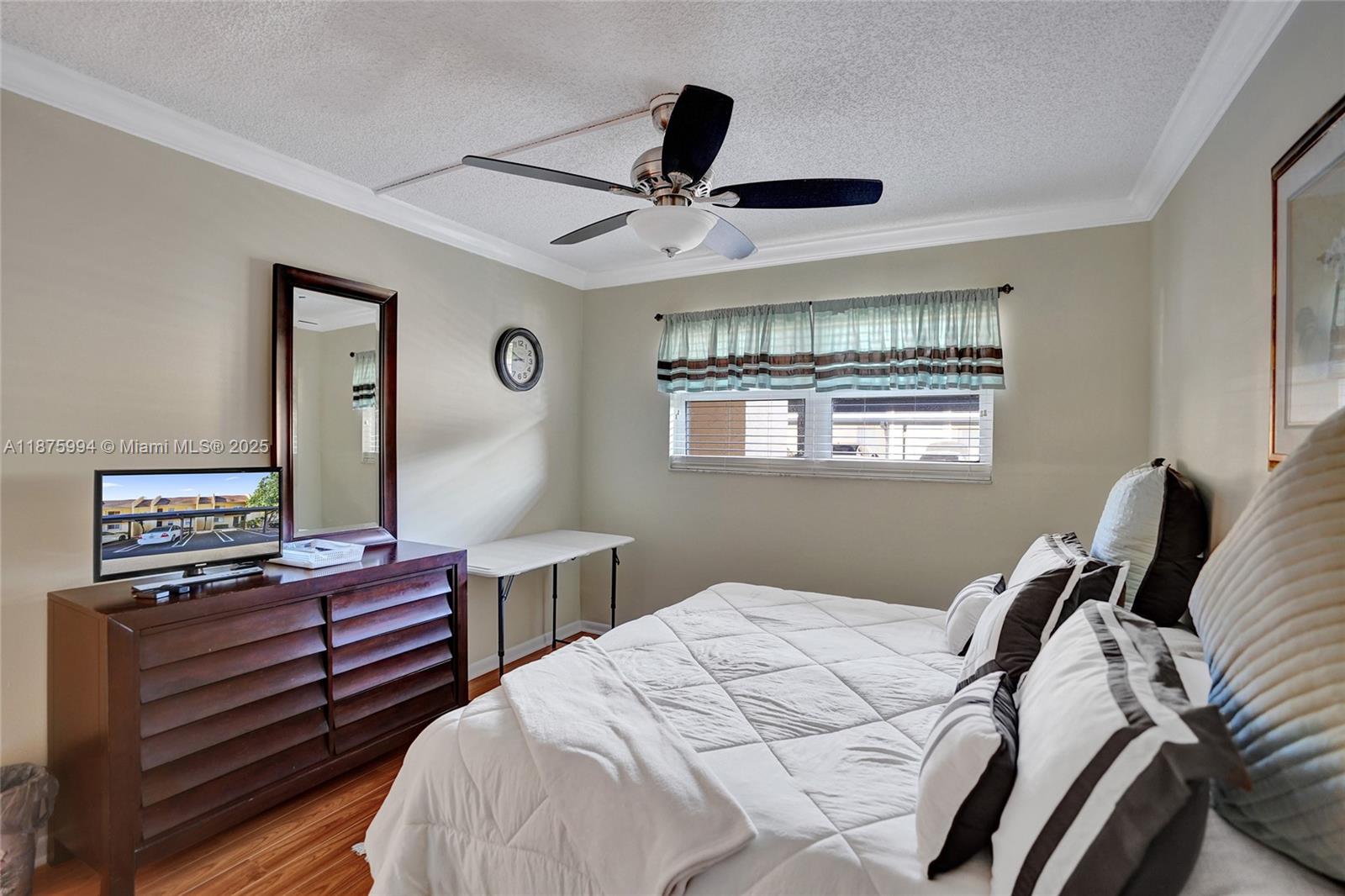 2975 Southwest 22nd Avenue, Unit 102 Delray Beach, FL 33445 - Photo 32 of 73 a bedroom with a bed and wooden floor