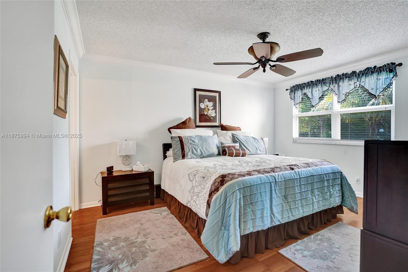 2975 Southwest 22nd Avenue, Unit 102 Delray Beach, FL 33445 - Photo 36 of 73 a bedroom with a bed and a chandelier