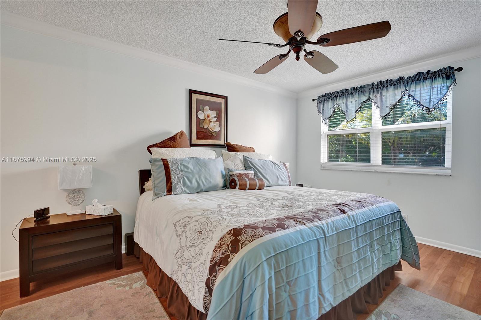 2975 Southwest 22nd Avenue, Unit 102 Delray Beach, FL 33445 - Photo 37 of 73 a bedroom with a bed and a chandelier
