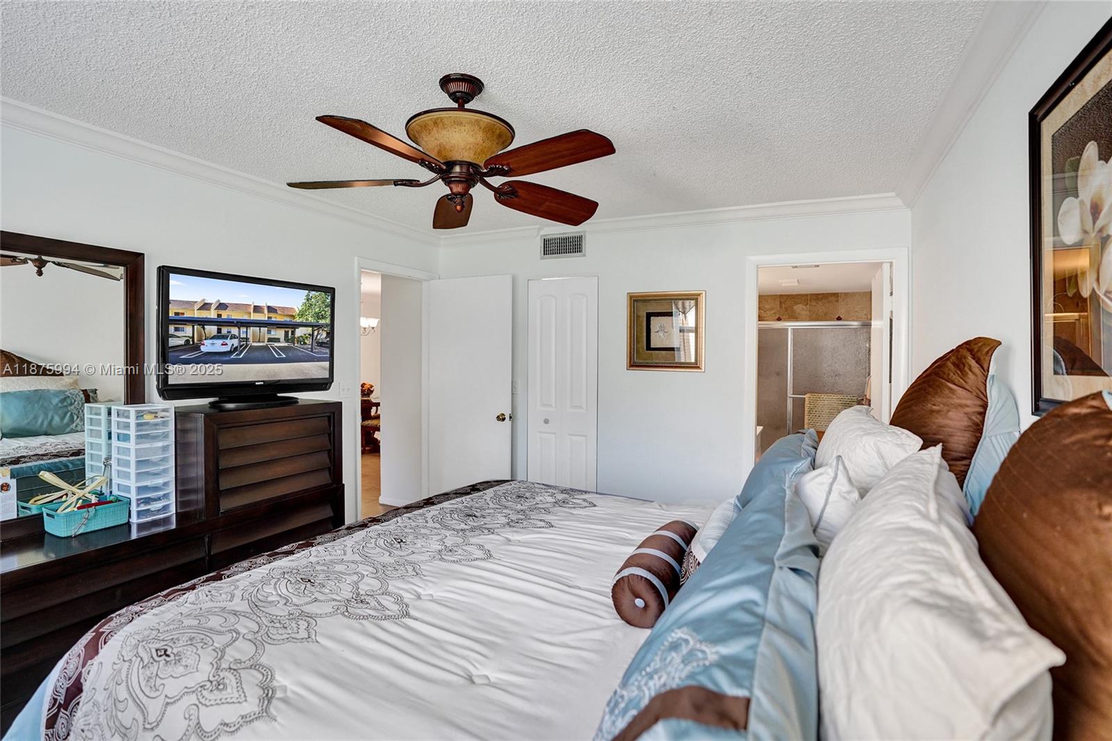 2975 Southwest 22nd Avenue, Unit 102 Delray Beach, FL 33445 - Photo 38 of 73 a bedroom with a bed and a chandelier