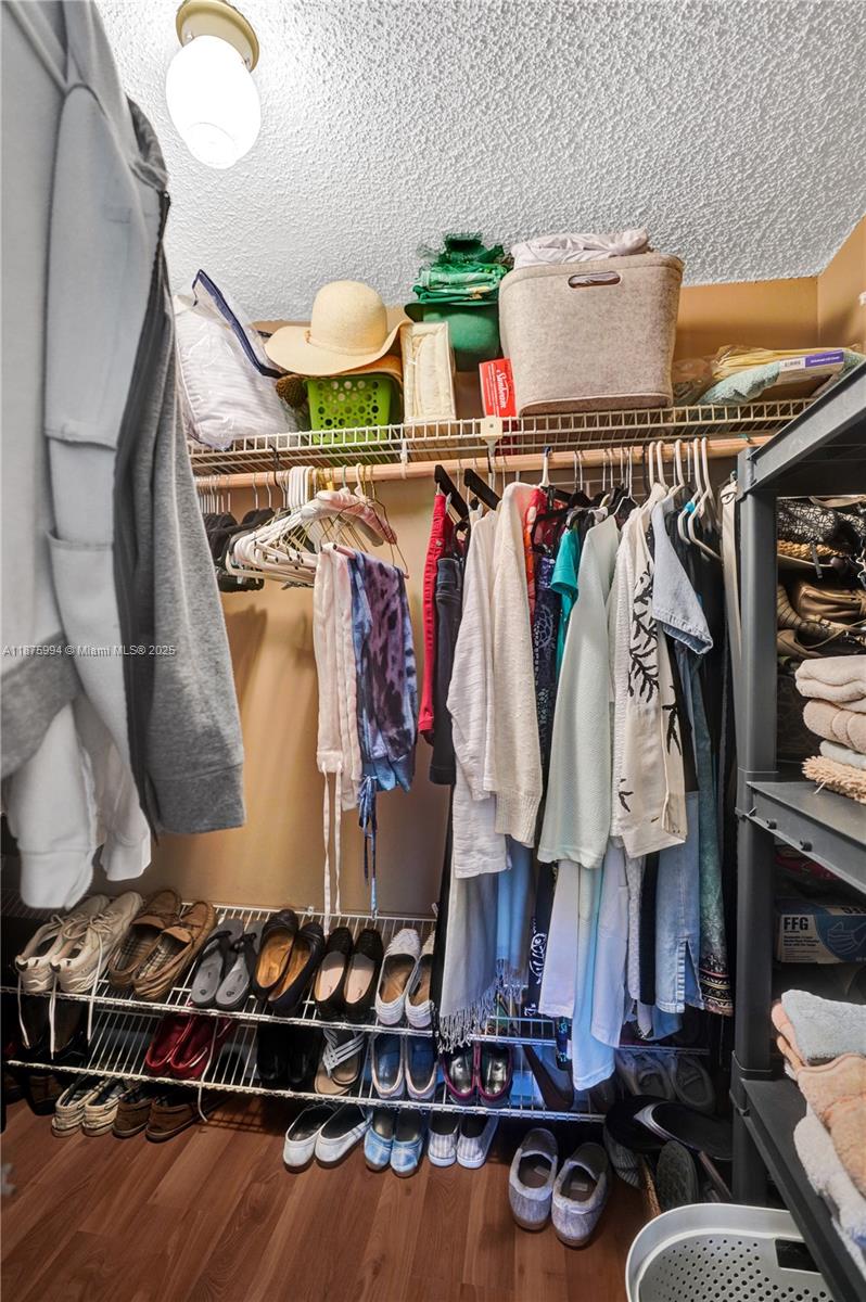 2975 Southwest 22nd Avenue, Unit 102 Delray Beach, FL 33445 - Photo 43 of 73 a view of walk in closet with clothes and shoes