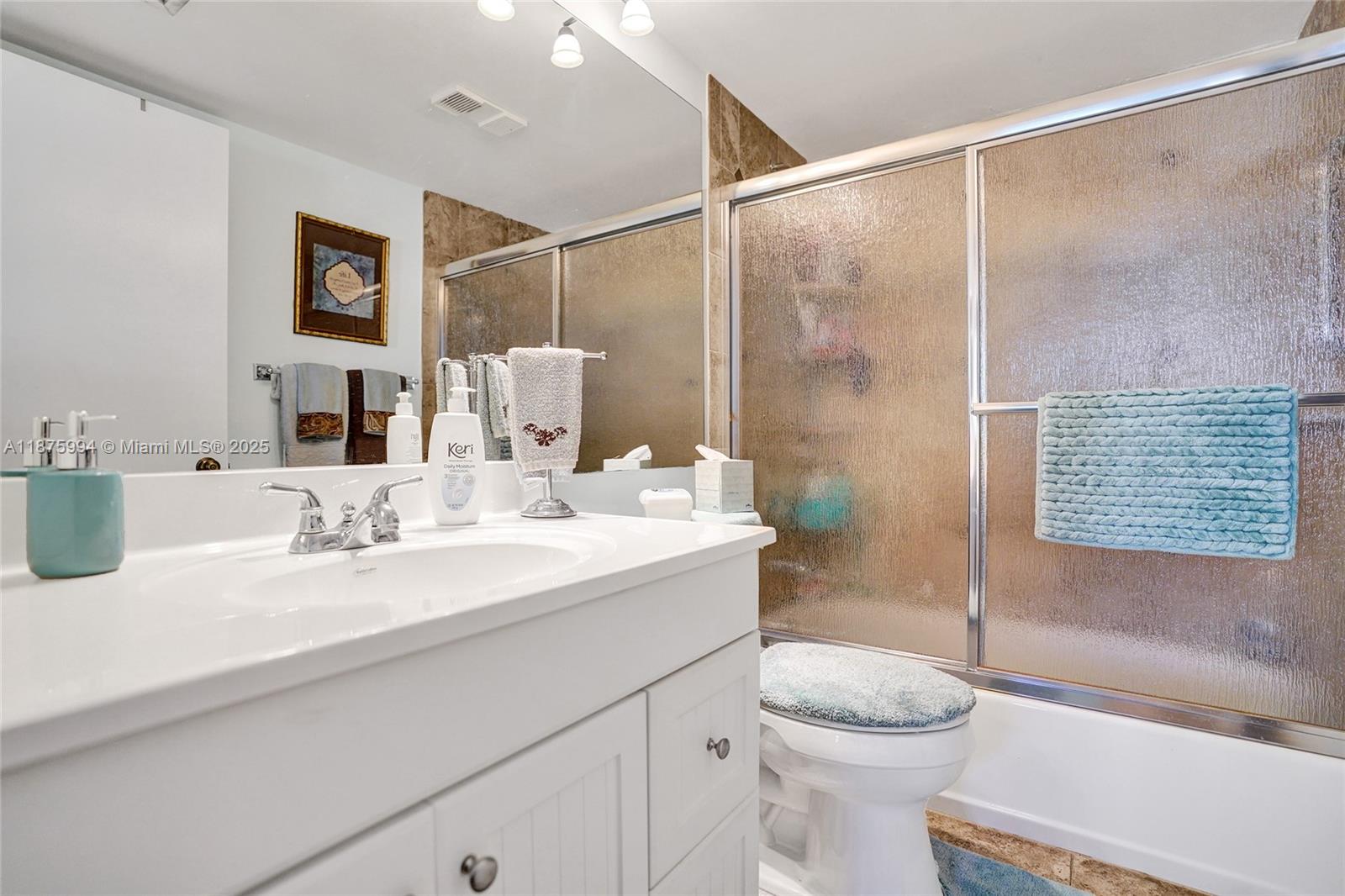 2975 Southwest 22nd Avenue, Unit 102 Delray Beach, FL 33445 - Photo 45 of 73 a bathroom with a sink toilet and shower