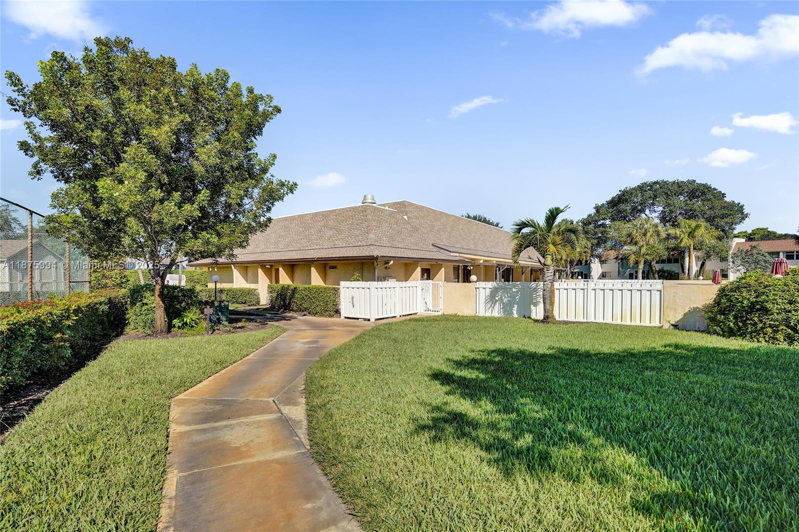 2975 Southwest 22nd Avenue, Unit 102 Delray Beach, FL 33445 - Photo 57 of 73 a front view of a house with a yard