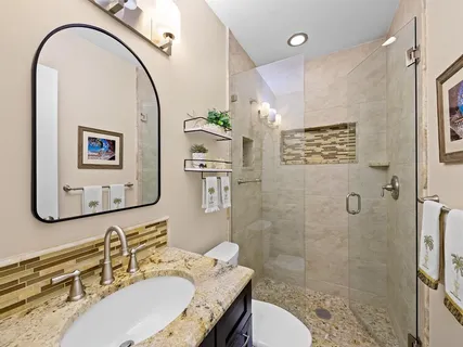 a bathroom with a sink a toilet and shower