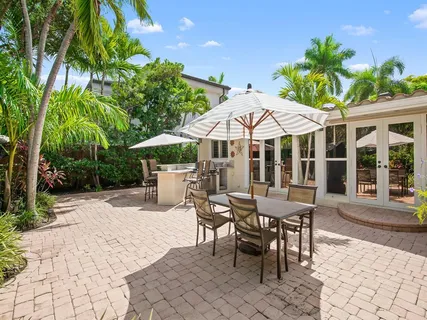 a view of a patio with a table and chairs under an umbrella
