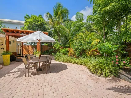 a view of a patio with table and chairs under an umbrella