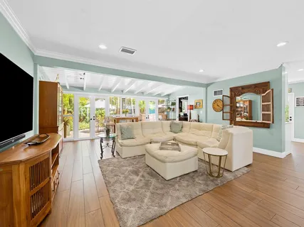 a living room with furniture a flat screen tv and wooden floor