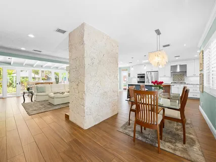 a dining room with furniture a chandelier and wooden floor