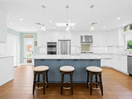 a kitchen with stainless steel appliances granite countertop a table chairs stove and kitchen view