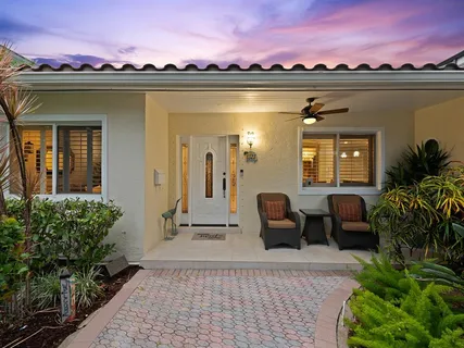 a view of a balcony with dining table and chairs with potted plants