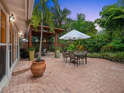 a view of a patio with table and chairs under an umbrella