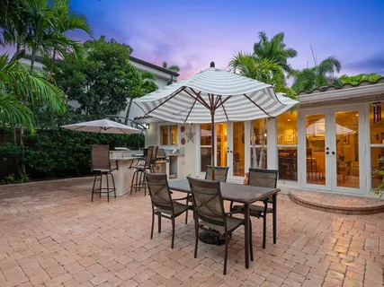 a view of a patio with a table and chairs under an umbrella