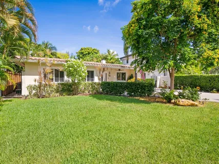 a front view of a house with porch and garden