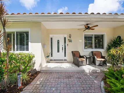 front view of a house with a potted plant and a chair