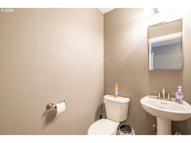 a bathroom with a toilet sink and mirror