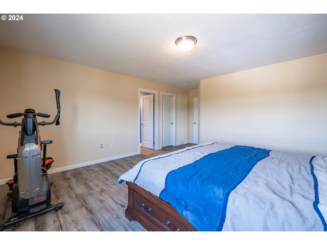 a bedroom with a bed and a wooden floor