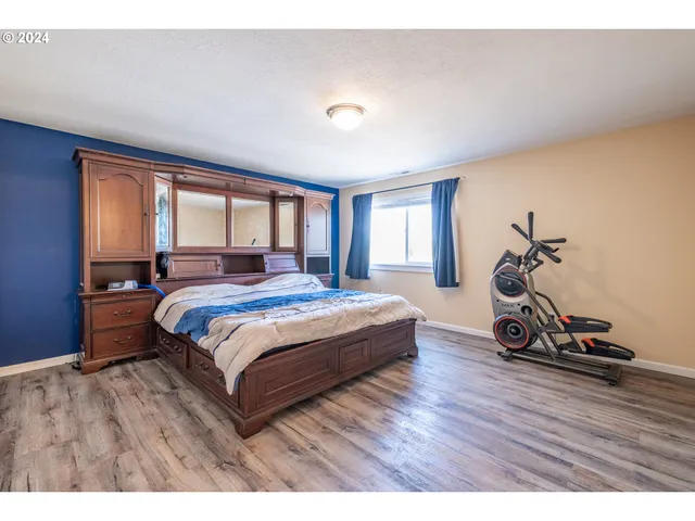 a bedroom with a bed and wooden floor