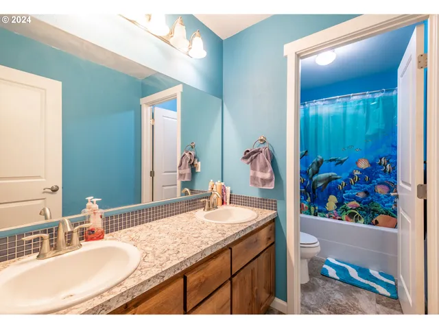 a bathroom with a granite countertop sink a mirror and a view of bathroom