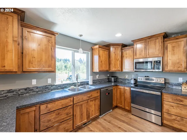 a kitchen with stainless steel appliances granite countertop sink stove and cabinets