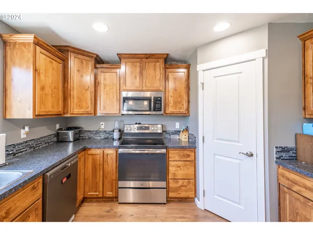 a kitchen with stainless steel appliances granite countertop a stove a sink and a refrigerator