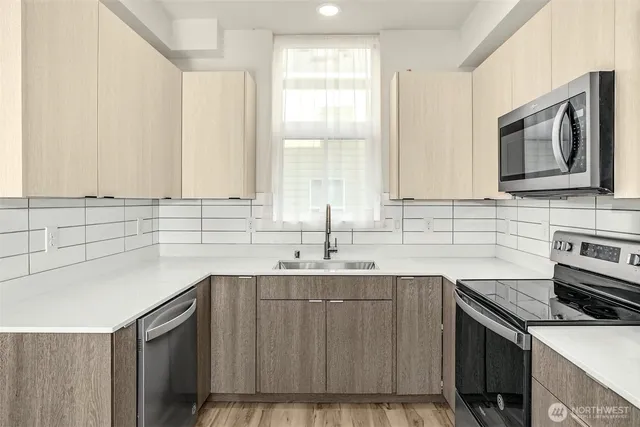 a kitchen with stainless steel appliances a refrigerator sink and microwave