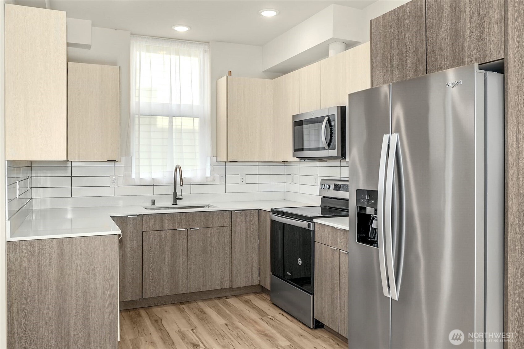 1400 North 95th Street Seattle, WA 98103 - Photo 12 of 27 a kitchen with stainless steel appliances a refrigerator sink and microwave