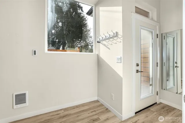 a view of a hallway with wooden floor and entryway