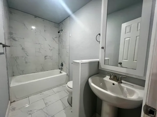 a bathroom with a sink a toilet and bathtub