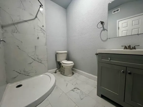a bathroom with a sink a toilet and shower