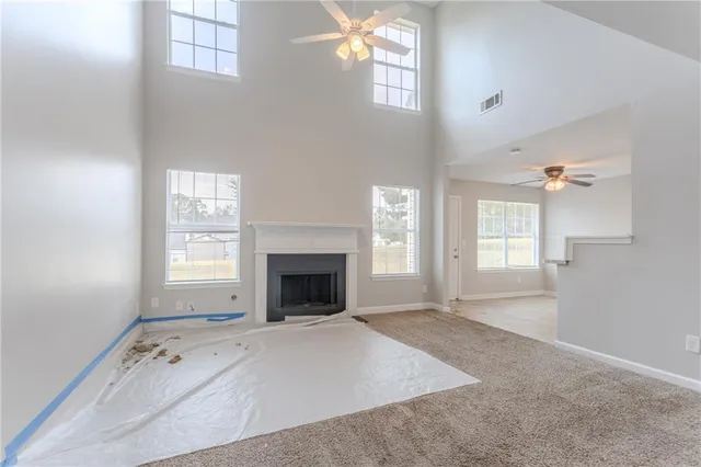 an empty room with windows and fireplace