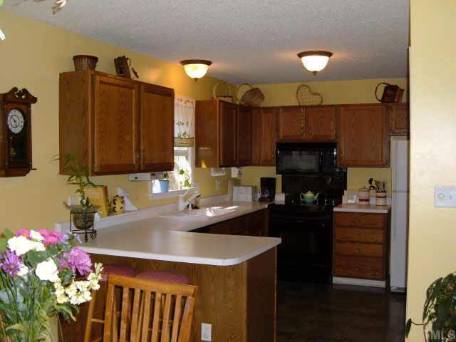 4804 Knightsbridge Way Raleigh, NC 27604 - Photo 3 of 5 a kitchen with a sink refrigerator and cabinets