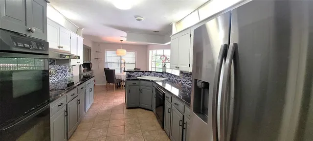 a kitchen with stainless steel appliances granite countertop a refrigerator a stove a sink and a microwave