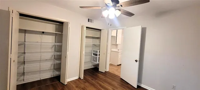 a view of a hallway with closet and wooden floor