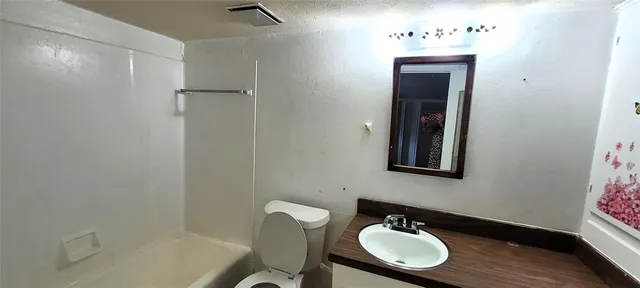 a bathroom with a sink mirror and a toilet
