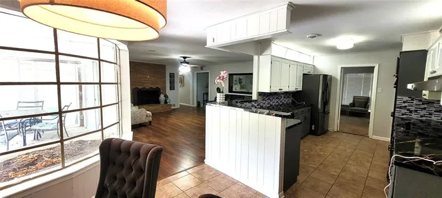 a kitchen with stainless steel appliances kitchen island granite countertop a refrigerator and a sink