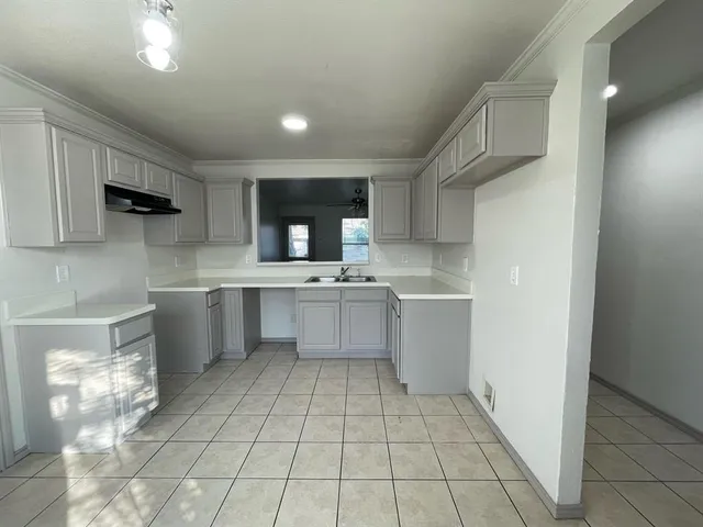 a kitchen with a sink a stove cabinets and counter space