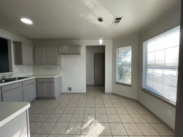 a large kitchen with a stove a sink dishwasher and a refrigerator