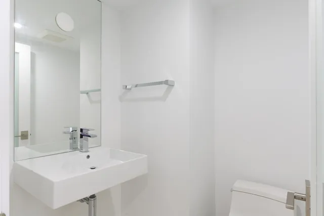a bathroom with a sink a toilet and a mirror