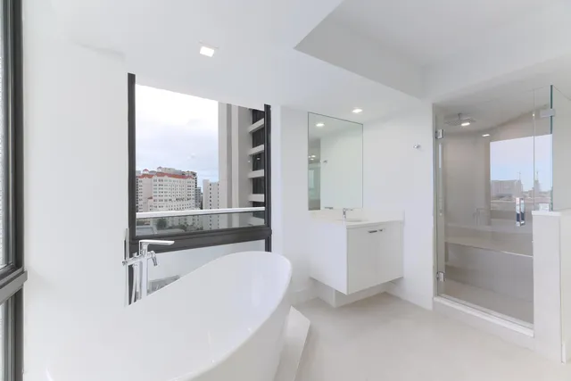 a bathroom with a tub a sink and a large mirror